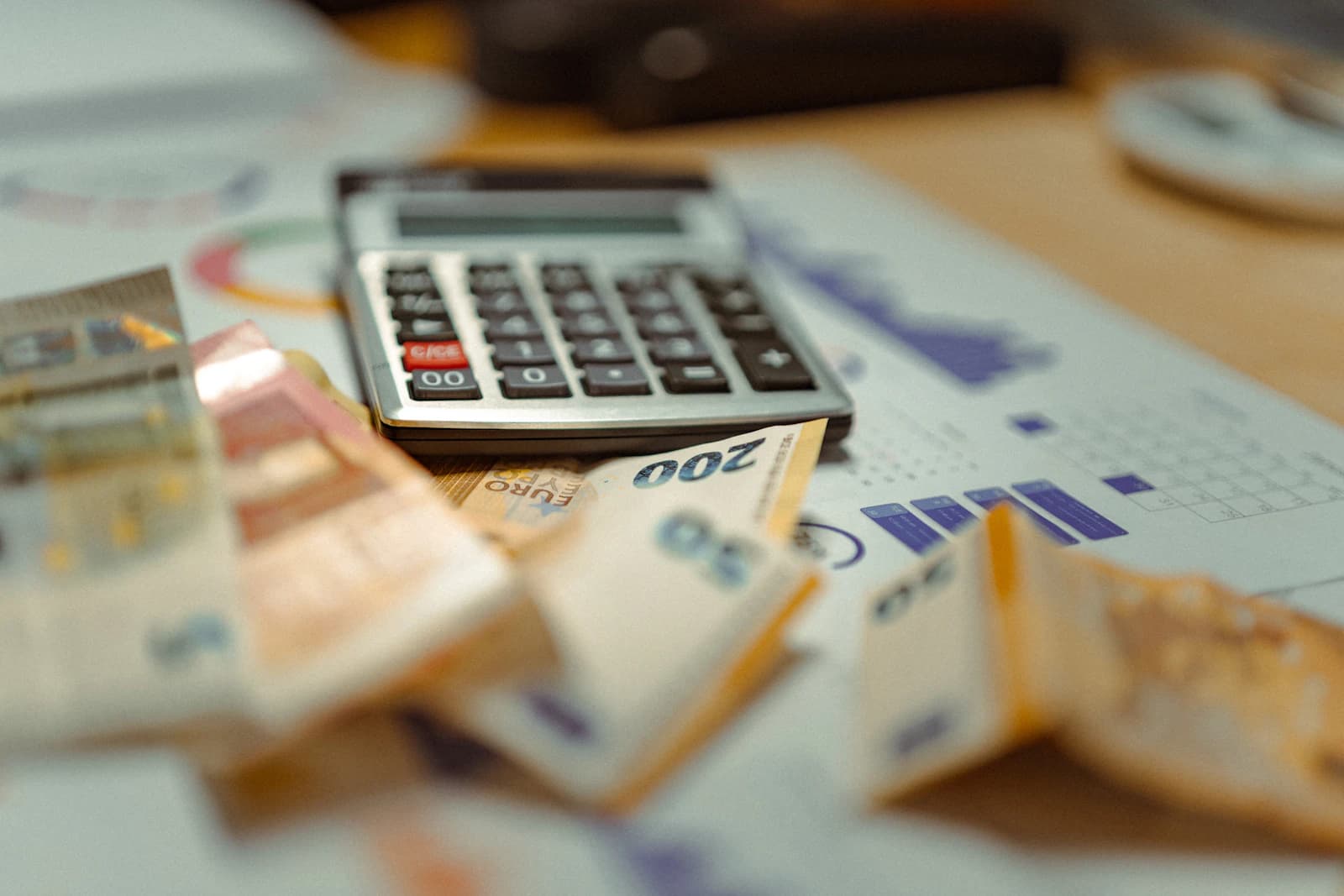 Calculadora sobre billetes de euro e informes impresos, imagen del coste real de poner en marcha un ERP con la fiscalidad española