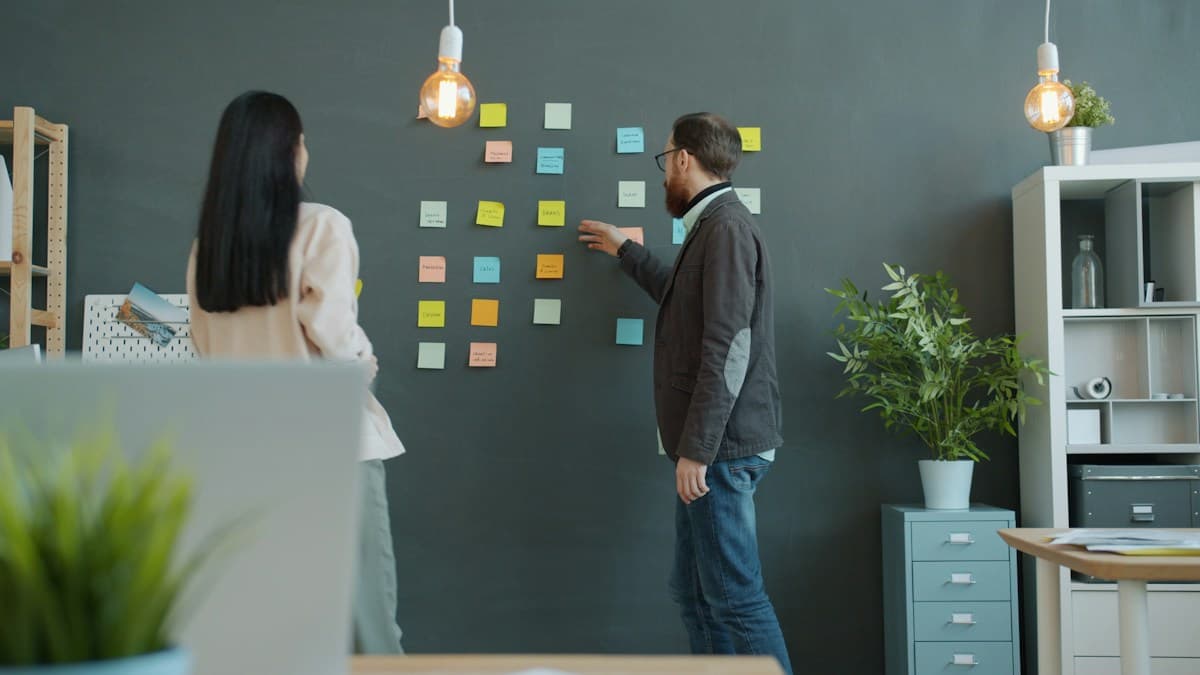 Dos personas organizan con notas adhesivas las fases de un proyecto de implantación de ERP