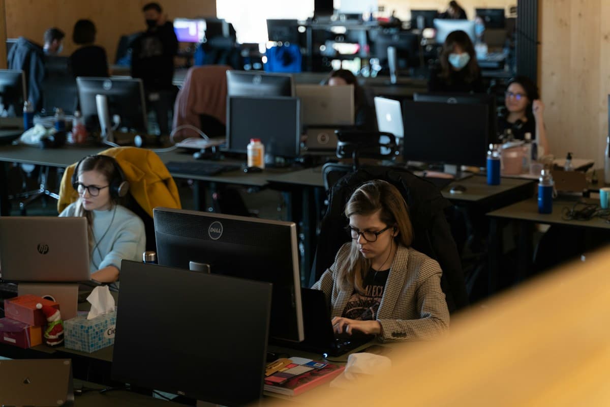 Personas trabajando frente a sus monitores en una oficina diáfana, la mañana normal de un equipo de soporte técnico