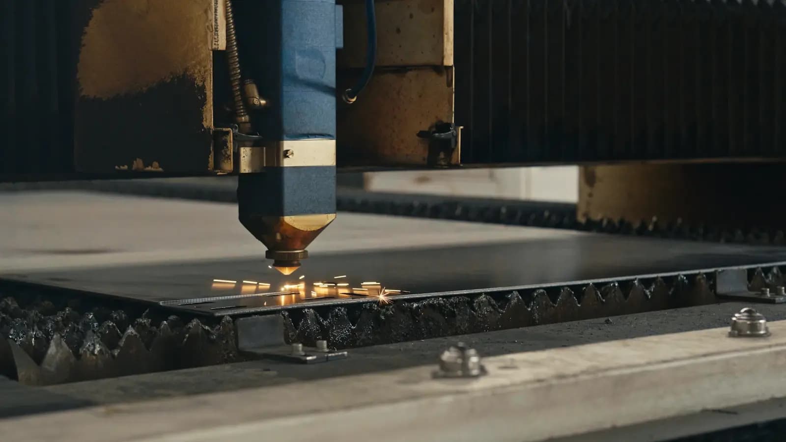 Cortadora láser trabajando sobre una chapa de acero en un taller, donde aparece la merma que la lista de materiales no recoge