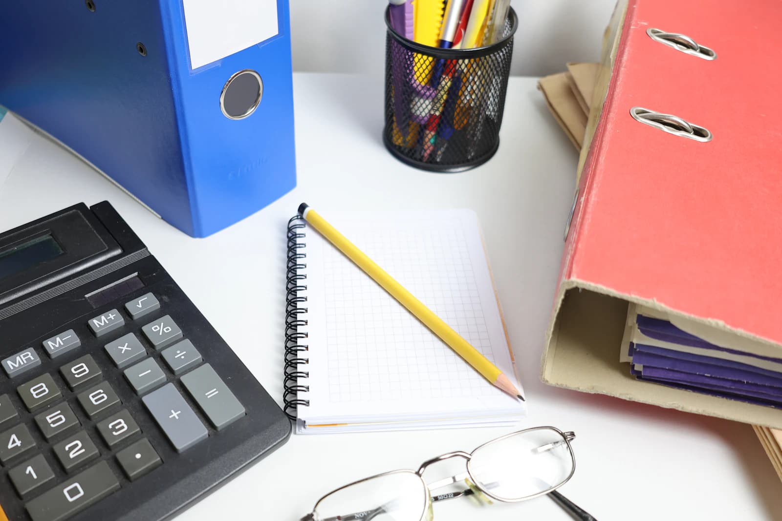 Calculadora, cuaderno y archivadores sobre la mesa, el cálculo del presupuesto cerrado para dejar SAP Business One