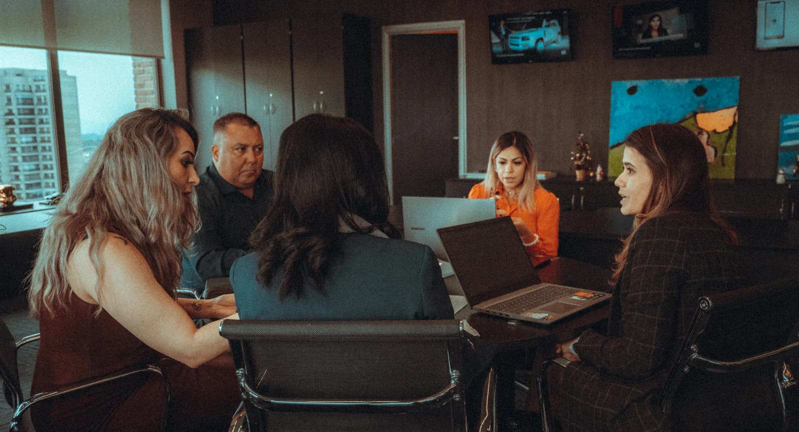 Equipo de dirección reunido con portátiles en una sala de oficina, valorando si dejar SAP Business One por ERPNext