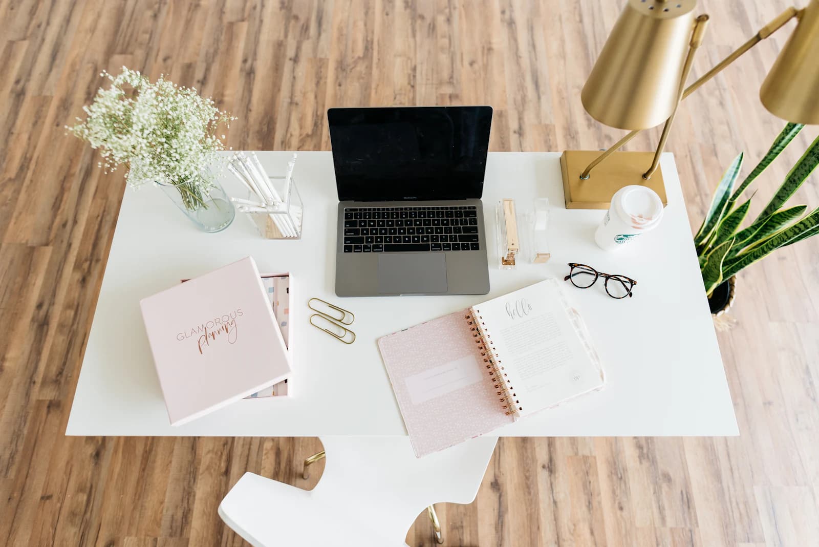 Escritorio con portátil, cuadernos, gafas y lámpara, un rincón de estudio para leer guías y comparativas sobre ERPNext