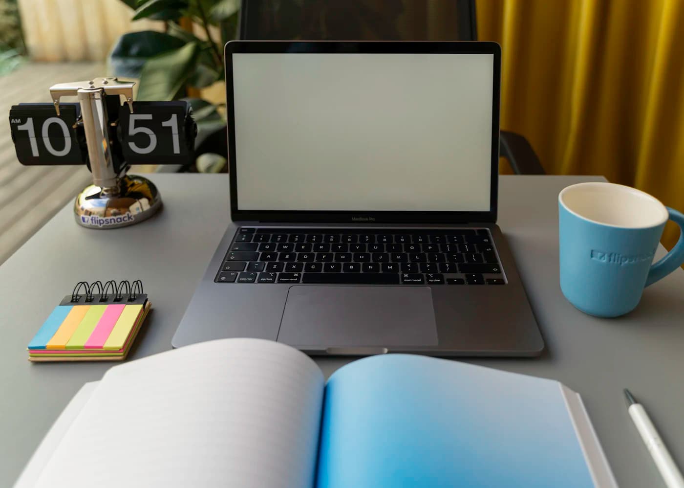 Portátil, cuaderno abierto, taza y reloj sobre la mesa, preparados para repasar con calma las guías y comparativas de ERPNext