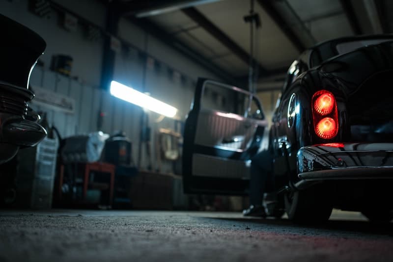Mecánico trabajando en un coche levantado en taller