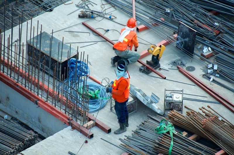 Obra de construcción con grúas y trabajadores con cascos