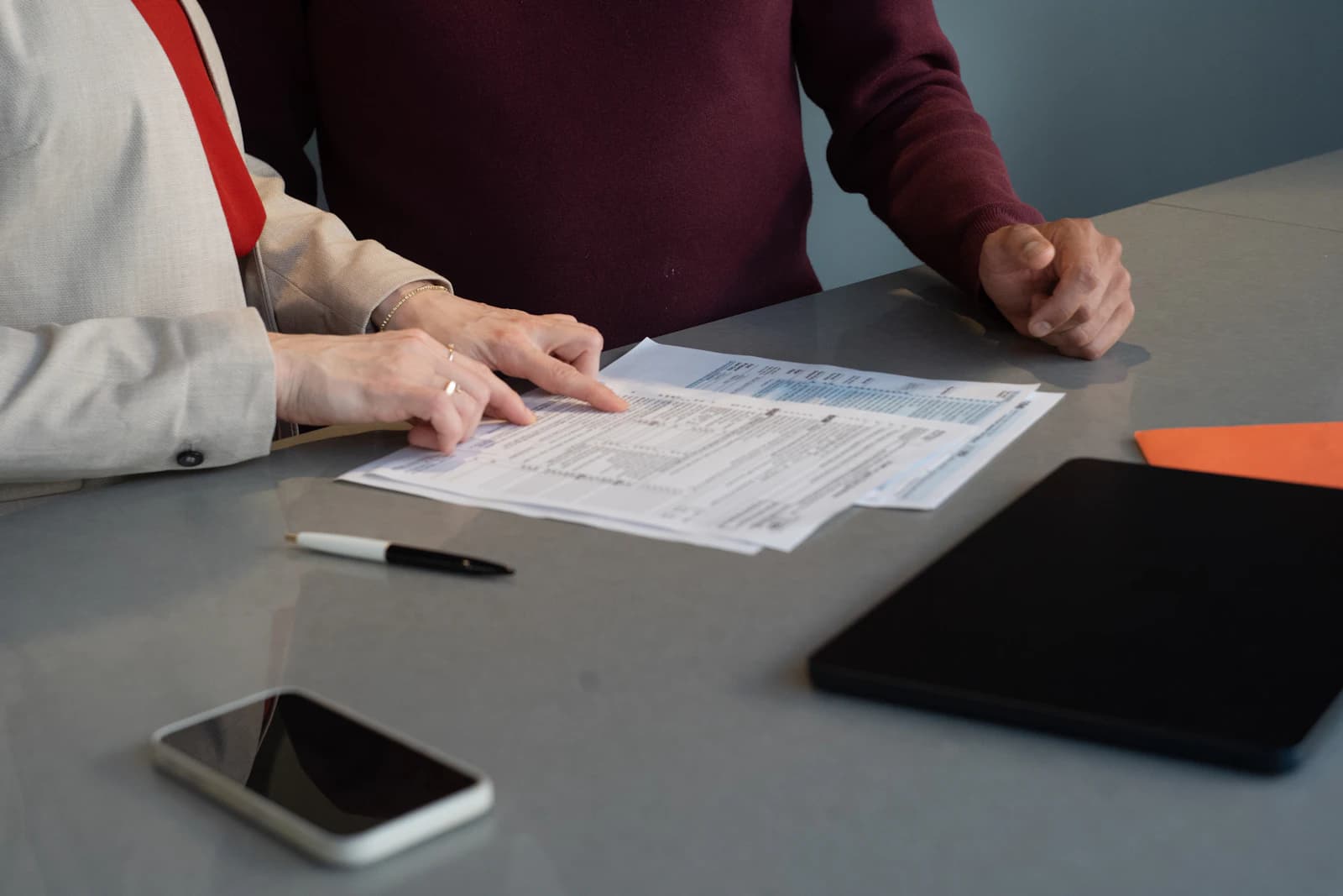Asesora y cliente repasando unos impresos sobre la mesa, la conversación sobre quién responde de VeriFactu